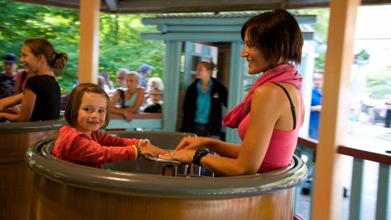 Photo d'une maman et de sa fille dans l'un des chaudrons du Tournicotti, les tasses du parc Bagatelle