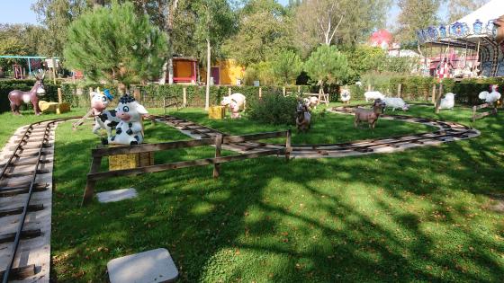 Photo de l'attraction des Cochons montrant le parcours du petit train qui plonge les enfants dans l'univers merveilleux des animaux de la ferme